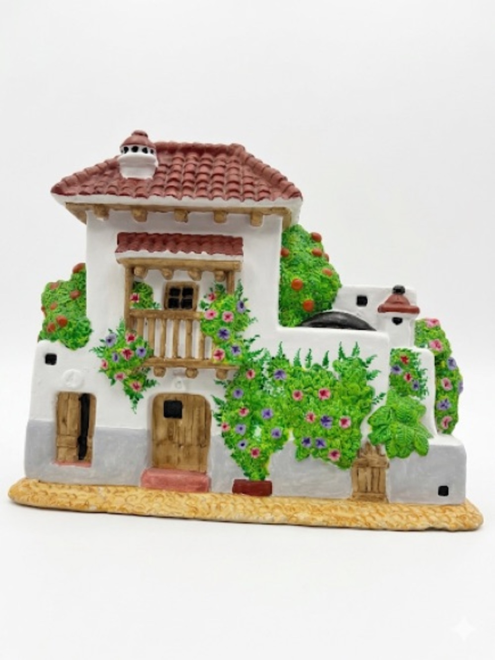 Mediterranean White House Sculpture with Red Roof and Green Foliage